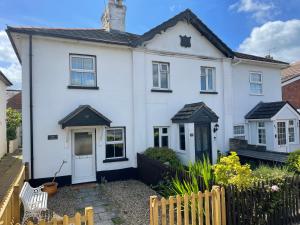 a white house with a black roof at April Cottage Ringwood in Ringwood