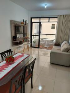 a living room with a table and a couch at Apto na Praia de Atalaia a 100 metros da Passarela do Caranguejo in Aracaju