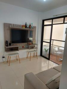 a living room with a flat screen tv and a couch at Apto na Praia de Atalaia a 100 metros da Passarela do Caranguejo in Aracaju