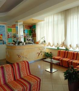 a living room with two chairs and a kitchen at Costa del Sole Only Room in Milano Marittima