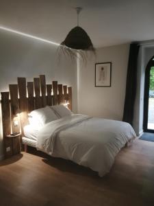 een slaapkamer met een groot wit bed en een raam bij Chambres d'hôtes de la pilatière in Persac
