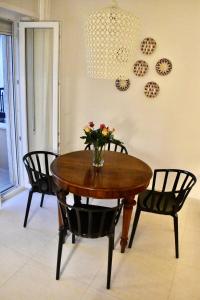 a table with chairs and a vase with flowers on it at Casa Pellegrino in Polignano a Mare