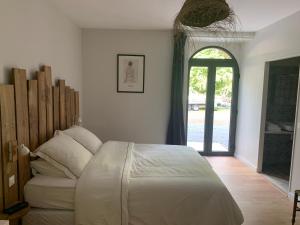 een slaapkamer met een bed en een open deur bij Chambres d'hôtes de la pilatière in Persac