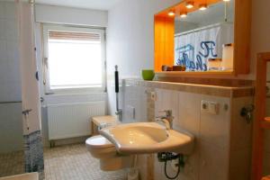 ein Badezimmer mit einem Waschbecken, einem WC und einem Spiegel in der Unterkunft FeWo Johan - ideal für 1-2 Personen, eigene Terrasse in Hamm