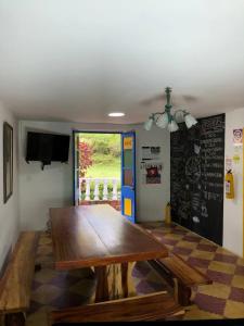 a dining room with a wooden table and a chalkboard at Alegria Hostel Boutique in Guatapé