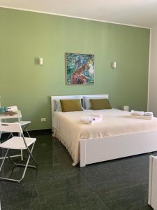 a bedroom with two beds and a table and a chair at I Venti in Brucoli