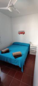 1 dormitorio con 1 cama azul y 2 almohadas en Apartamento 34 La Tortuga I, en Tarifa