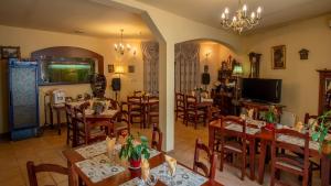 a restaurant with tables and chairs and a television at Pensiunea Alpin in Păltiniş