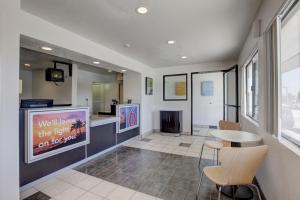 a waiting room with a tv and a table and chairs at Motel 6-Corona, CA in Corona