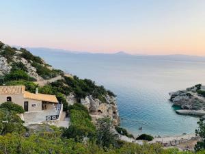a house on a cliff next to the ocean at Lake and Sea in Vouliagmeni Lake
