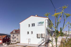 a white building with a staircase in front of it at Apartamentos Playa de Finisterre in Fisterra