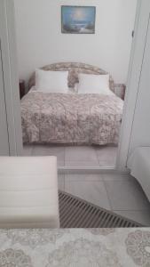 a small bedroom with a bed and a mirror at Apartments Zdenka in Marina
