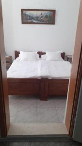 1 cama con sábanas blancas y almohadas en una habitación en Apartments Zdenka, en Marina