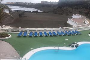 un complejo con piscina, sillas y el océano en Vivienda con encanto, en un complejo con piscina, en La Estrella