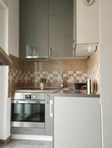 a kitchen with white cabinets and a stainless steel oven at Stan na dan Zvornik in Zvornik