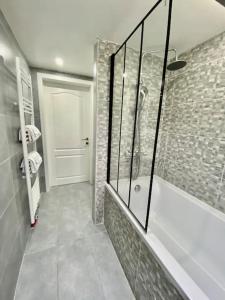 baño con ducha a ras de suelo y puerta de cristal en Peaceful home close to Airport with parking, en Steenokkerzeel
