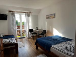 a bedroom with a bed and a table and chairs at Dom Wypoczynkowy Sztorm in Ostrowo