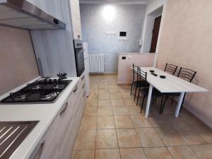 uma cozinha com um fogão e uma mesa com cadeiras em HappyHome, Belissimo appartamento in Torino em Turim