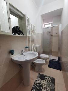 La salle de bains est pourvue d'un lavabo, de toilettes et d'un miroir. dans l'établissement HappyHome, Belissimo appartamento in Torino, à Turin
