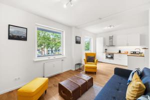 a living room with a blue couch and a kitchen at Apartment near Volksoper - Modern, Big, Central, Cosy in Vienna