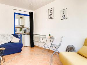 een woonkamer met een bank en een tafel bij Studio Aline à la Plage - Détente en bord de mer in Canet-en-Roussillon
