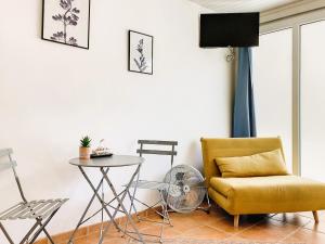 een woonkamer met een stoel en een tafel bij Studio Aline à la Plage - Détente en bord de mer in Canet-en-Roussillon