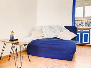 een blauwe bank in een kamer met een tafel bij Studio Aline à la Plage - Détente en bord de mer in Canet-en-Roussillon
