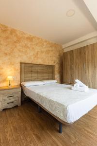 a bedroom with a large bed and a wooden floor at GTCS Mendoza in Málaga
