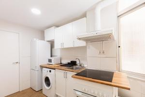 a white kitchen with a sink and a microwave at GTCS Mendoza in Málaga