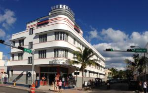 Sherbrooke All Suites Hotel في ميامي بيتش: مبنى ابيض عليه لافته جانبيه