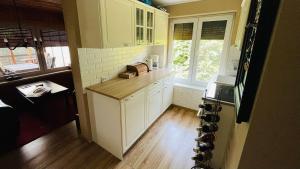 a kitchen with white cabinets and a wooden floor at Pod Świerkami in Boszkowo