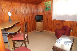 a room with a desk and a tv and a chair at SOFT ROOMS in Vila Real