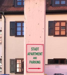 een bord met een personeelsappartement en een parkeerplaats voor een gebouw bij Stadt Apartment in Günzburg