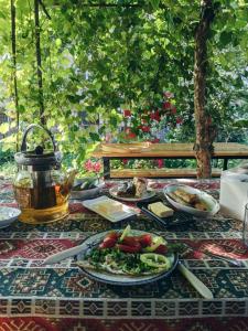 - une table avec des assiettes de nourriture et une bouilloire dans l'établissement Aregak B&B and Tours, à Goris