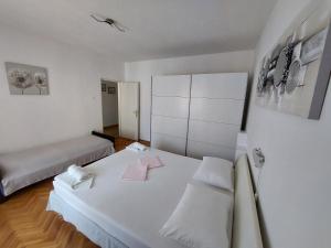 a white room with a bed and a couch at APARTMENT ELI in Pag