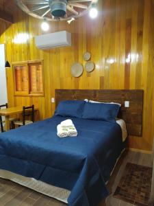 um quarto com uma cama azul e um cobertor azul em Aconchego da Serra Geminados em São Joaquim