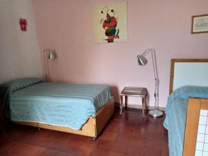 um quarto com uma cama e um candeeiro em Il Giardino dei Merli em Bussoleno