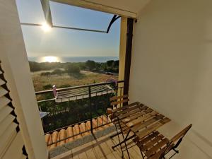 a balcony with a bench looking out at the sunset at Gullo Capo Vaticano in Ricadi
