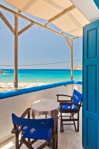 Aegean View Studios في ليفكوز كارباثو: طاولة وكراسي على شرفة مع الشاطئ