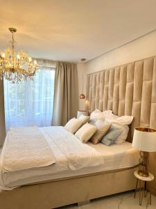 um quarto com uma grande cama branca e um lustre em Kamin und Fußbodenheizung, Luxrem Apartments best in Homeoffice em Remscheid