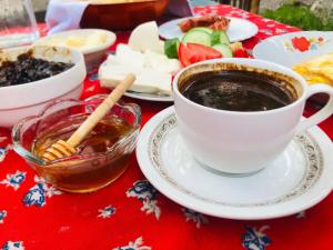 ヴァルボナにあるGuest house Hyrmet Demushiのテーブルに座ってコーヒーを飲みながら食事を楽しめます。