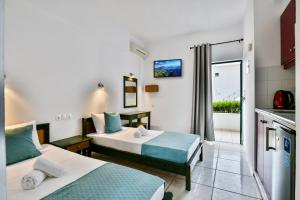 een hotelkamer met twee bedden en een keuken bij Villa Maria Apts in Kato Gouves +15 foto's
