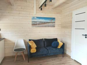 ein Wohnzimmer mit einem blauen Sofa und einem Pier in der Unterkunft RIWIERA-SARBINOWO in Sarbinowo