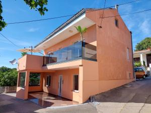 pomarańczowy dom z palmą na boku w obiekcie La Dama w Novim Vinodolskim