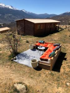 a bed sitting on top of a field with a house at Les Chalets De Lozzi in Calacuccia
