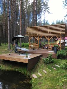 a wooden gazebo with a bench and a table at Reinholdi puhkemaja in Jabara