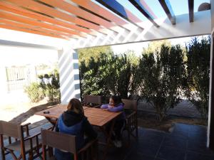 two women sitting at a table under a pergola at Casa Quinta in Villa Unión