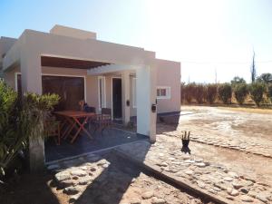 une maison avec une table et des chaises devant elle dans l'établissement Casa Quinta, à Villa Unión