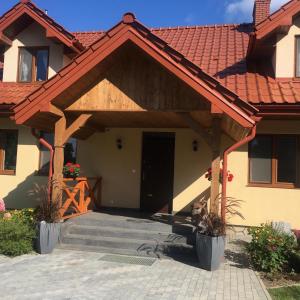 a house with a wooden door and a porch at Przytulisko na Mazurach in Ruciane-Nida