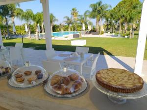 - une table avec deux assiettes de pâtisseries et un gâteau dans l'établissement Tenuta Espada Luxury Residence, à Gallipoli